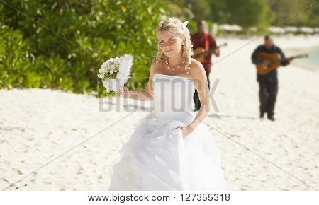 Gorgerous Bride Walking To Wedding Ceremony On The Beach With Bouquet