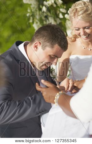 Gorgerous Wedding Couple Putting Their Signatures In Marriage Certificate During Ceremony.