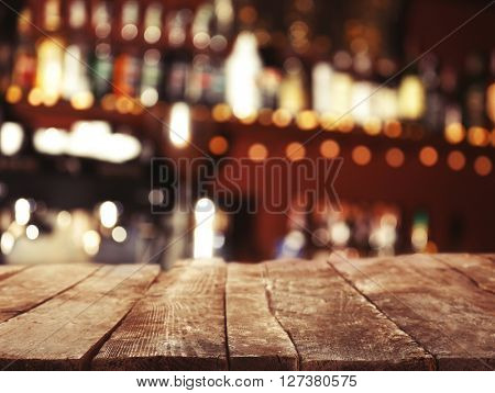 Empty wooden table and bokeh pub, bar of restaurant background.