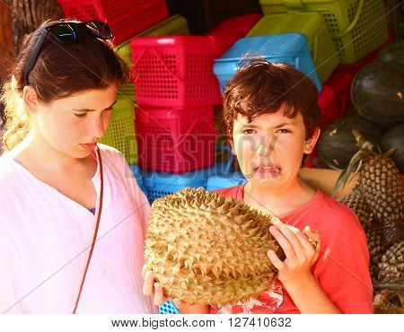 pre teen boy smell durian - tropical fruit with good taste but bad smell
