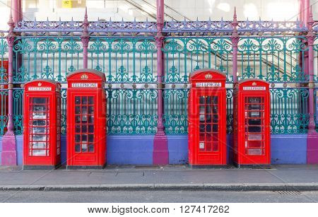 Traditional British red phone booths in a row at an old market in London