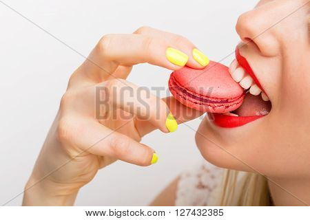 Happy and bright woman eating macaroon cookie