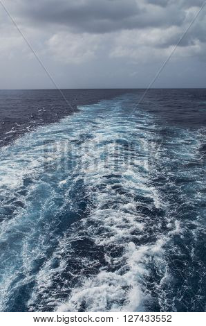 The wake of a cruise ship flows from the rear of the ship in the Caribean Sea