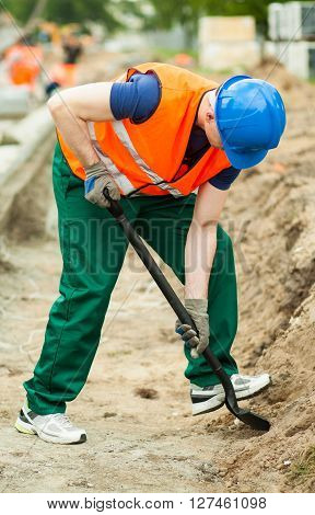 Image of man with shovel digging at work zone
