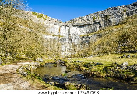 Limestone cliffs of Malham Cove in North Yorkshire, England on sunny day.