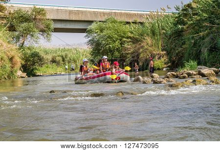 JORDAN RIVER ISRAEL - OCTOBER 2: Group of teenagers rafting on the Jordan River in Israel on October 2 2015