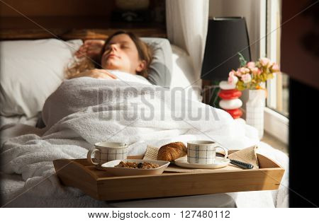 Healthy breakfast in the morning served on tray in bed with coffee, cornflakes, croissant and milk