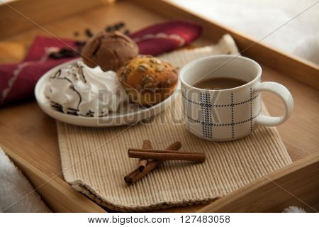 Sweet breakfast in bed served on tray with coffee and cupcakes