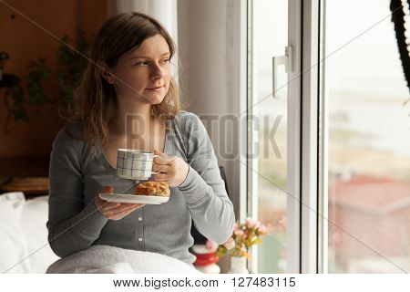 Healthy breakfast in bed served on tray with coffee, cornflakes, croissant and milk