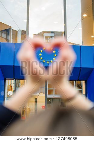 Woman hands in shape of love heart with the stars of European Union in the lhearts shape