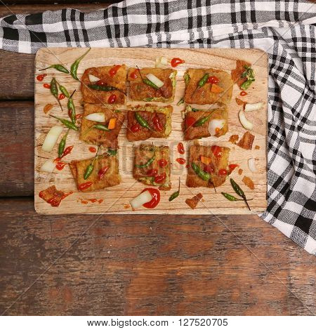 Top view of veggie martabak with chili peppers and hot souce
