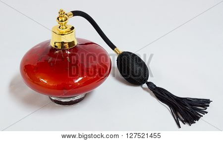 Red perfume spray bottle with tassle isolated on white