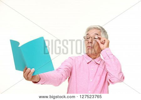 senior Japanese man with presbyopia on white background