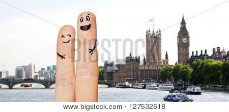 family, couple, travel, tourism and body parts concept - close up of two fingers with smiley faces over london city with big ben clock tower and thames river background