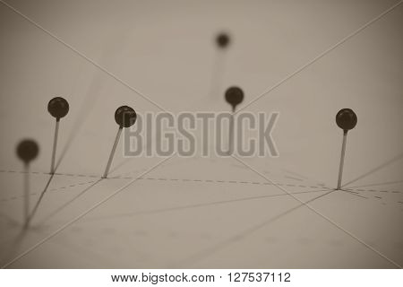 Black Pins In Paper Linked By Lines