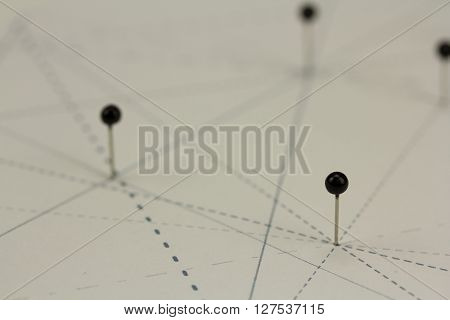 Black Pins In Paper Linked By Lines