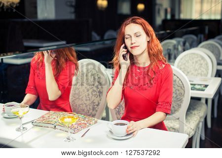 Beautiful  woman using 
laptop, phone at table in cafe