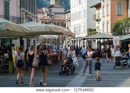 Lecco, Italy - September 1st 2015: pedestrians walking past shops and restaurants in a central street in Lecco Italy 