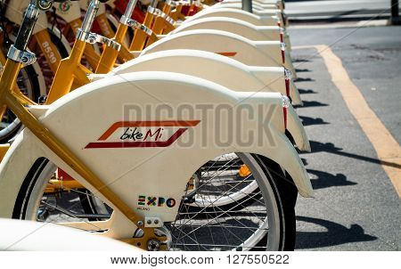 Milan, Italy - September 5th 2015: closeup photo of yellow and white hire bicycles in Milan Italy.