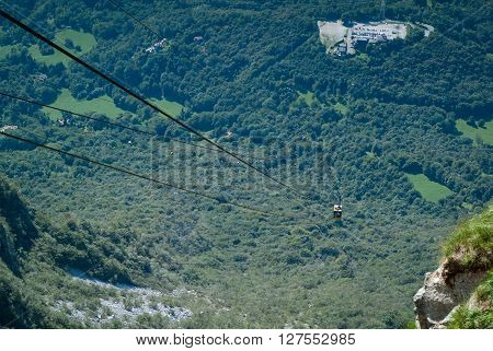 a yellow cable car carrying passengers down from Piani d'Erna (part of the Italian Alps)