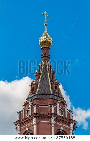 The Golden dome with an Orthodox cross on a background of blue sky