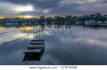 Dawn on the river Fal in Cornwall, England - long exposure, with a boat moored in the forefront of the frame