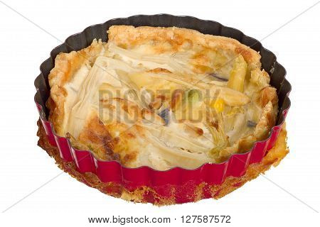 Handmade quiche in a small baking dish isolated on white background.