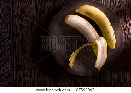 Bananas on old wooden background. (dark style)