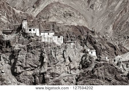 Ruins and Basgo Monastery surrounded with stones and rocks Leh Ladakh Jammu and Kashmir India black and white image tinted.