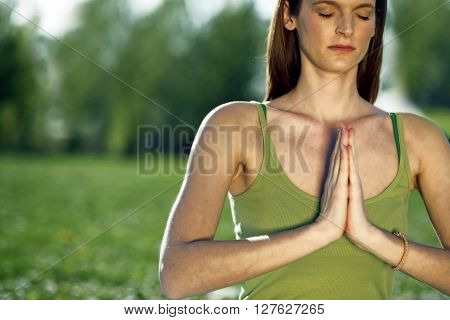 Young women practise yoga by day in nature