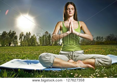 Young women practise yoga by day in nature
