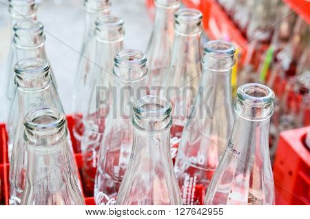 BANGKOK, THAILAND - JULY 28: Empty recycle bottles of Coca Cola in red plastic box on July 28, 2015 in Bangkok, Thailand. Coca Cola drinks are produced and manufactured by The Coca-Cola Company