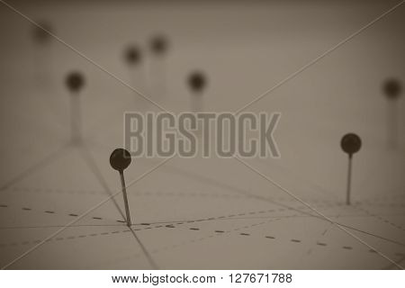 Black Pins In Paper Linked By Lines
