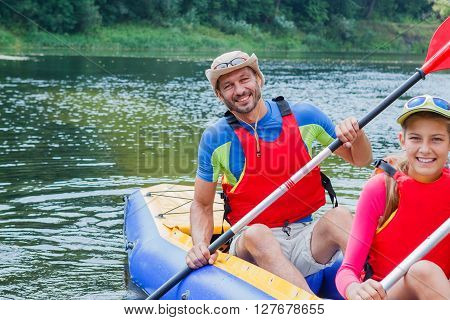 Active happy family. Father with his daughter having fun together enjoying adventurous experience kayaking on the river on a sunny day during summer vacation