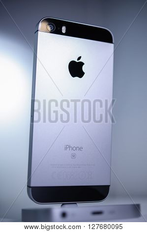 PARIS FRANCE - APR 21 2016: Rear view of the new Apple iPhone SE in docking station combining the updated processor 4K rear camera touch id retina display