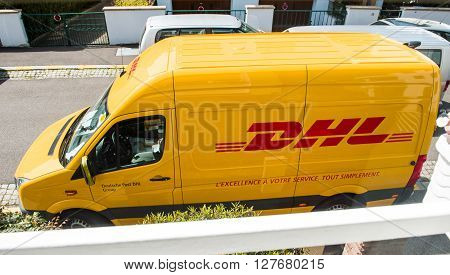PARIS FRANCE - APR 21 2016: DHL yellow delivery van delivering the on time package parcel - view from above
