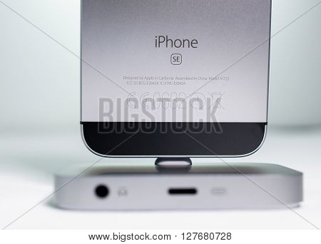 PARIS FRANCE - APR 21 2016: Front view of the new Apple iPhone SE in docking station combining the updated processor 4K rear camera touch id retina display
