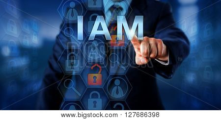Security manager is pushing IAM on a touch screen interface. Information technology security concept for Identity and Access Management that is controlling access rights to data resources.