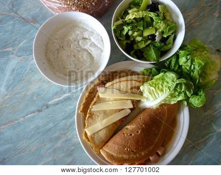 Filled Pancakes Served With Green Salad And Sauce