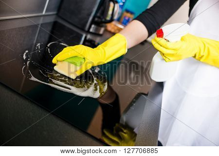 Woman’s Hands Cleaning Induction Cooker
