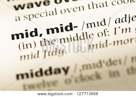 Close Up Of Old English Dictionary Page With Word Mid.