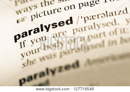 Close Up Of Old English Dictionary Page With Word Paralysed.