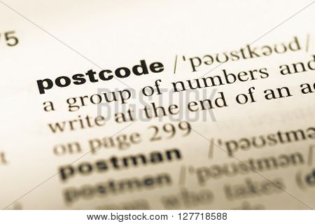 Close Up Of Old English Dictionary Page With Word Postcode.