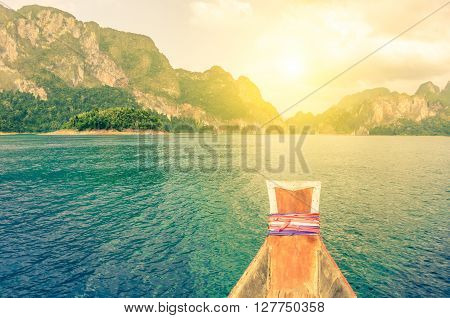 Point of view of Cheow Lan lake from long tail boat - Khao Sok National Park in Thailand - Adventure travel concept with wanderlust feelings - Enhanced sunflare halo with vivid vintage filter