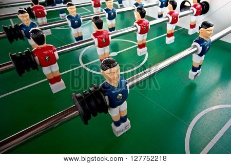 Miniature figures of players fixed on rods .