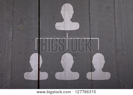 White organigram with white heads on dark black wooden background