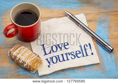 Love yourself advice - handwriting on a napkin with a cup of espresso coffee and cookie against grunge painted wood