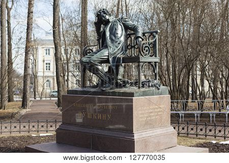 Tsarskoye Selo, Russia -April 16, 2016: Sculpture of a man in a cloak, sitting on a bench, on a high granite pedestal. The monument to Pushkin in Lyceum garden. Sculptor: P.P. Bach. Opened in 1899-1900 gg.