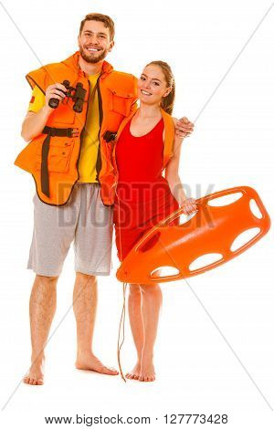 Lifeguards with rescue tube buoy and life vest jacket looking through binoculars. Man and woman supervising swimming pool. Accident prevention.