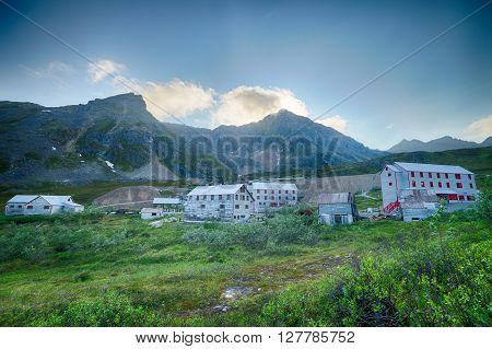 Aging buildings of an Alaskan gold rush town beneath the mountains.